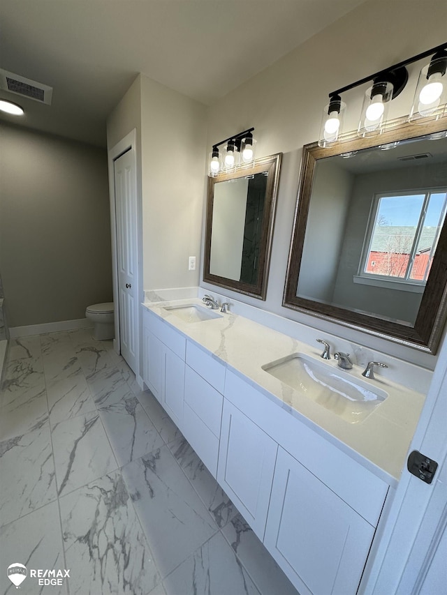 bathroom featuring marble finish floor, double vanity, a sink, and visible vents