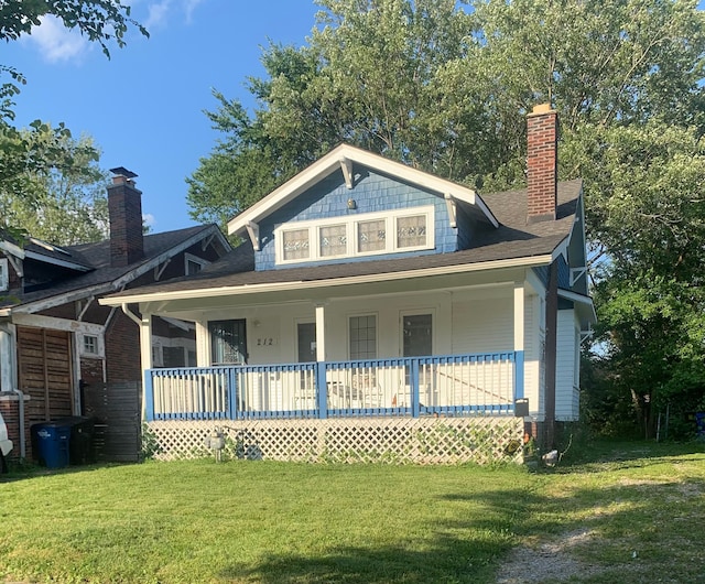 view of front facade featuring covered porch and a front yard