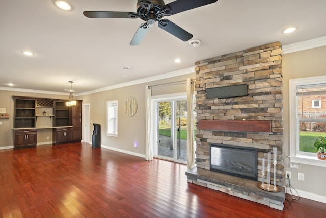 unfurnished living room with baseboards, dark wood-style flooring, ornamental molding, and a fireplace