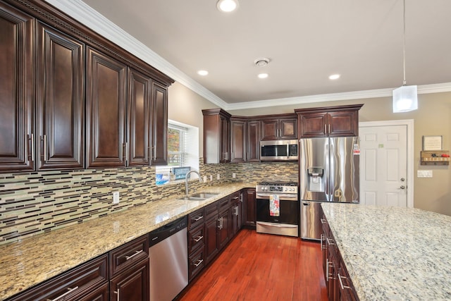 kitchen featuring ornamental molding, a sink, light stone counters, dark wood-style floors, and appliances with stainless steel finishes