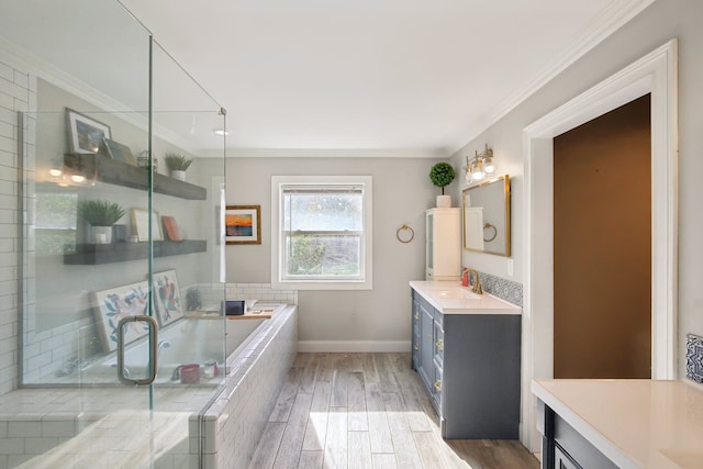 bathroom featuring vanity, wood finished floors, a shower with shower door, ornamental molding, and a garden tub