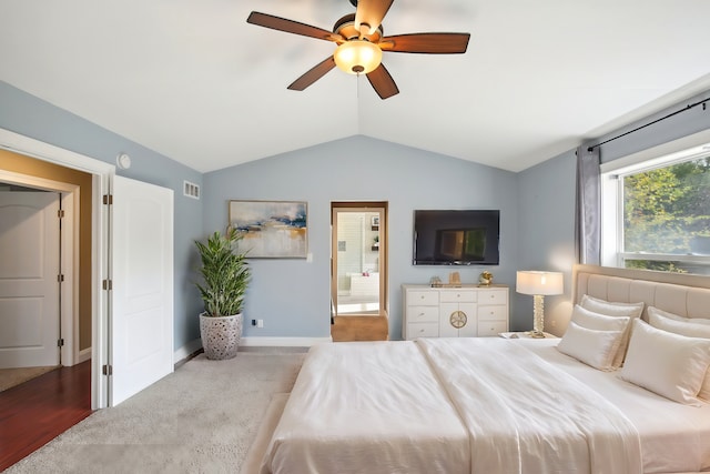 carpeted bedroom featuring visible vents, ceiling fan, baseboards, vaulted ceiling, and ensuite bath