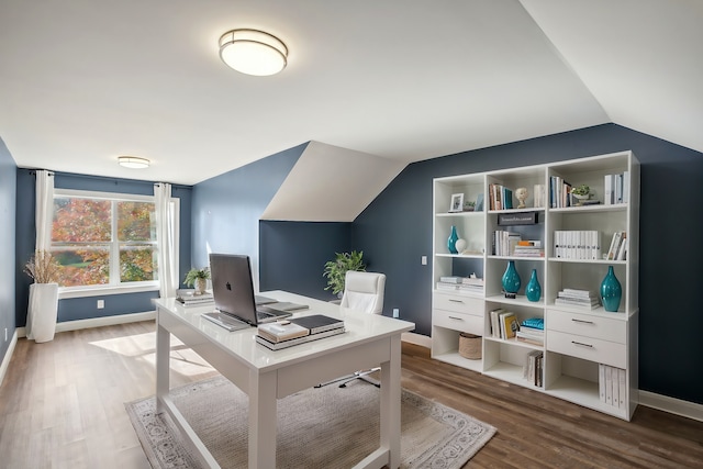 office featuring lofted ceiling, wood finished floors, and baseboards