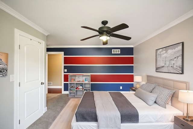 bedroom featuring crown molding, wood finished floors, visible vents, and ceiling fan