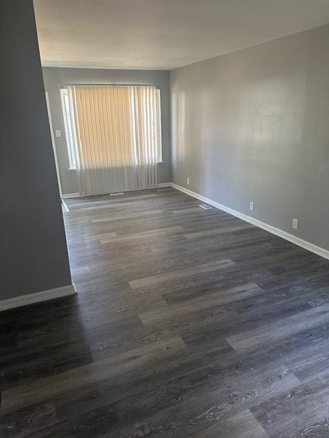 unfurnished room with dark hardwood / wood-style floors