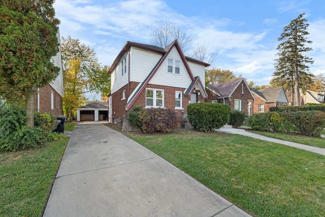 view of front of house with a front yard, a garage, and an outdoor structure