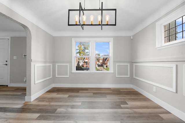 unfurnished dining area with hardwood / wood-style flooring and a notable chandelier