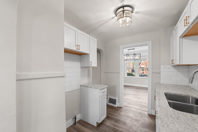 kitchen featuring tasteful backsplash, white cabinetry, sink, and dark hardwood / wood-style floors