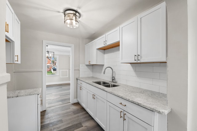 kitchen with backsplash, dark hardwood / wood-style flooring, white cabinetry, and sink