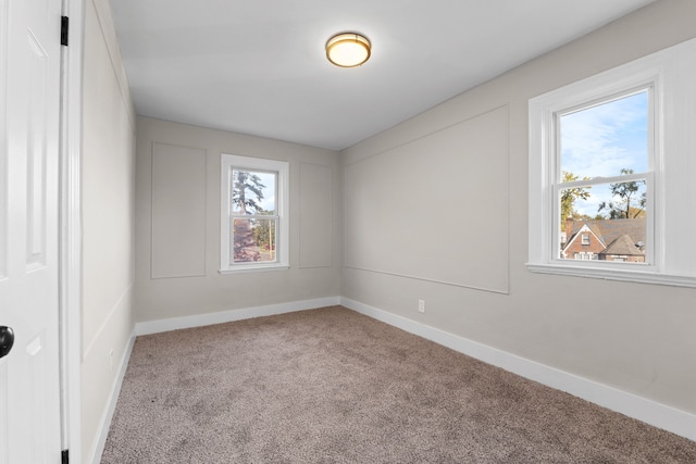 carpeted spare room featuring a healthy amount of sunlight