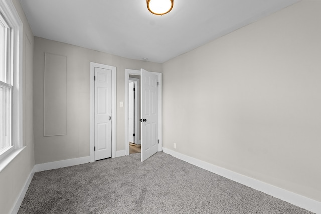 unfurnished bedroom with carpet floors and multiple windows