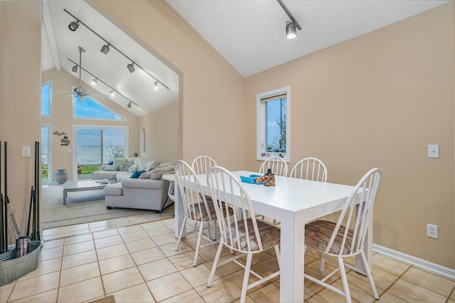 dining room with ceiling fan, light tile patterned flooring, high vaulted ceiling, and track lighting