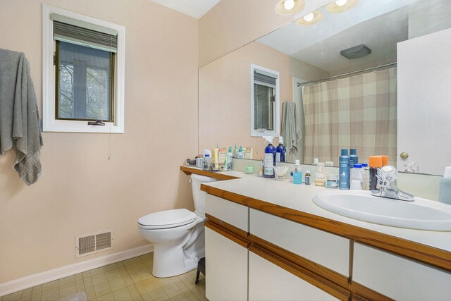 bathroom with vanity, a shower with shower curtain, and toilet