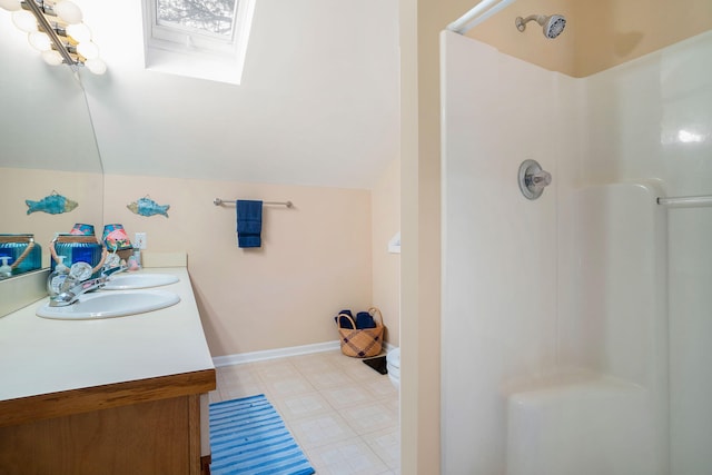 bathroom with vanity, lofted ceiling with skylight, and walk in shower