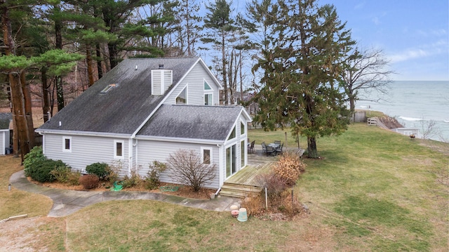 view of property exterior with a deck with water view and a yard