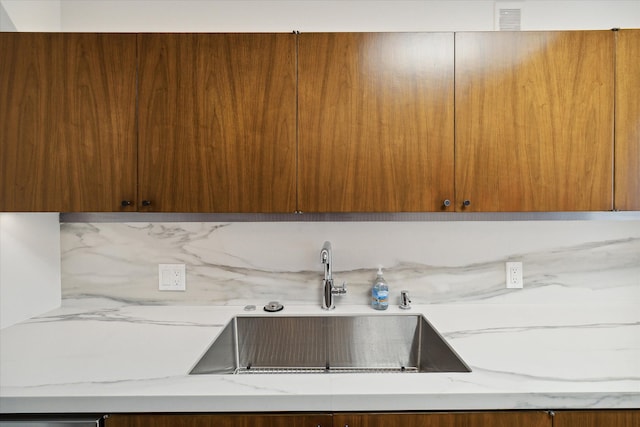 interior space featuring light stone counters and sink