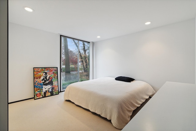 carpeted bedroom featuring a wall of windows