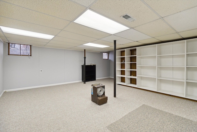 basement with a paneled ceiling and carpet