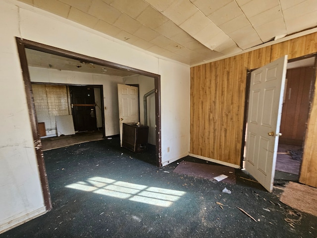 spare room with wooden walls and dark colored carpet