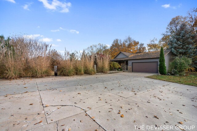 2766 48th Ave, Zeeland, MI 49464 - view of home's exterior with driveway, a garage, and stone siding