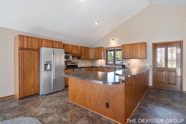 2766 48th Ave, Zeeland, MI 49464 - kitchen with appliances with stainless steel finishes, a peninsula, brown cabinets, dark countertops, and decorative backsplash
