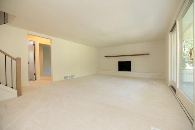 unfurnished living room featuring stairway, carpet flooring, a fireplace, and visible vents