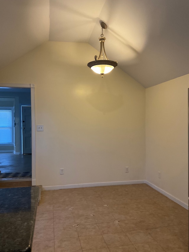 empty room with tile patterned flooring and vaulted ceiling