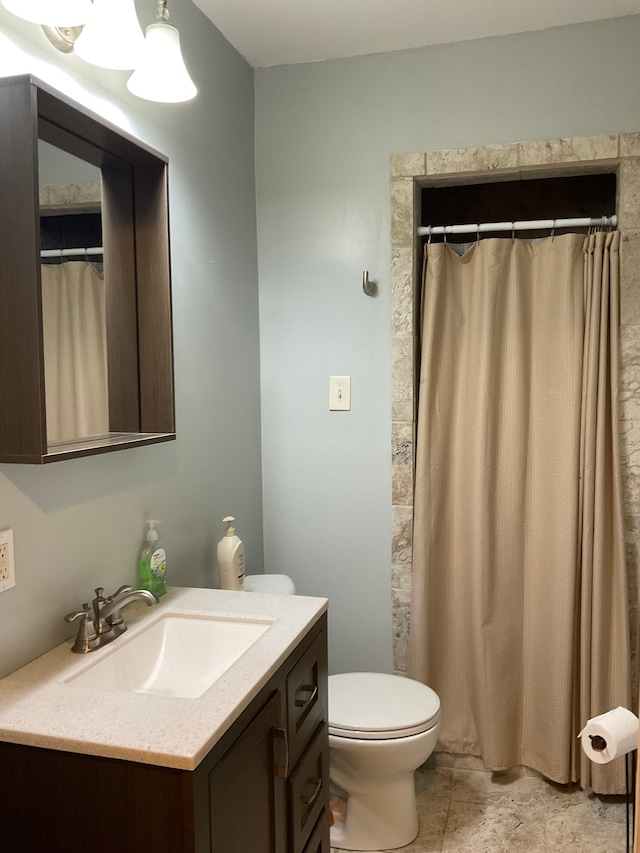 bathroom with a shower with shower curtain, vanity, and toilet