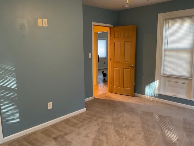 spare room featuring light carpet and ceiling fan