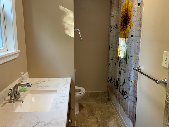 bathroom featuring vanity, toilet, and walk in shower