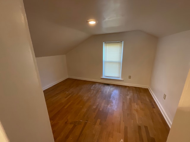 bonus room with wood-type flooring and vaulted ceiling