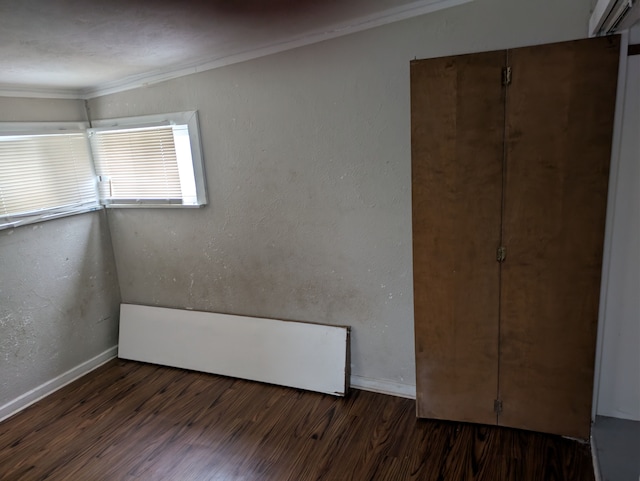 unfurnished bedroom featuring crown molding and dark hardwood / wood-style flooring