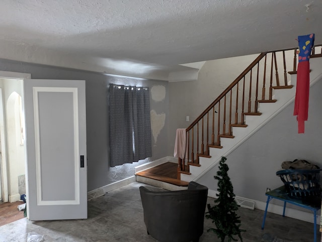 staircase featuring a textured ceiling