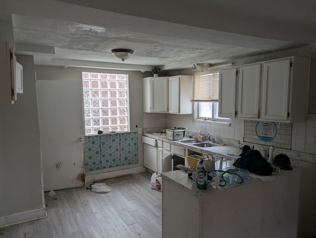 kitchen featuring sink, white cabinetry, light hardwood / wood-style floors, and plenty of natural light