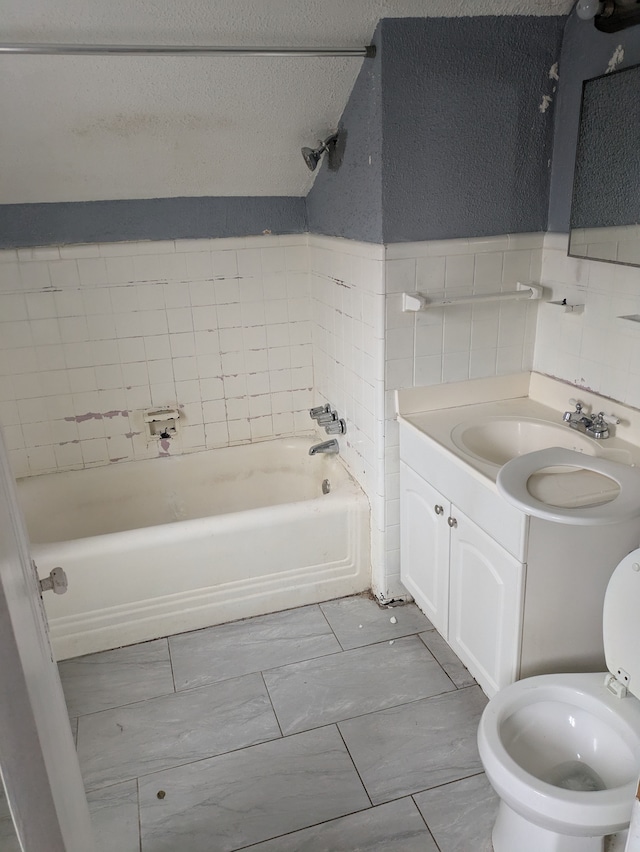 full bathroom featuring vanity, toilet, tile walls, and tiled shower / bath combo