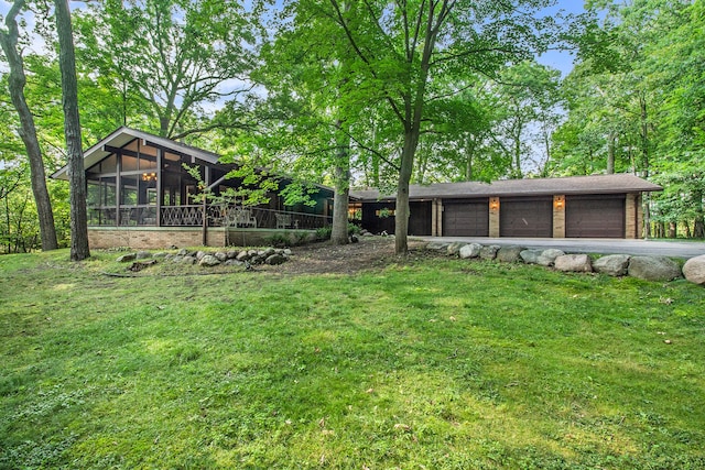 view of yard featuring a sunroom and a garage