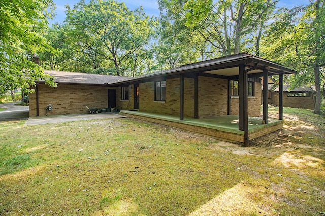 rear view of house featuring a yard and a patio