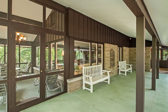 unfurnished sunroom with vaulted ceiling and a chandelier