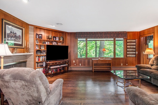 living room with a fireplace, dark hardwood / wood-style flooring, built in features, and wooden walls