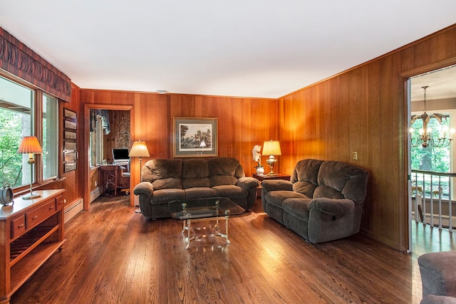 living room featuring dark hardwood / wood-style flooring, wooden walls, and a chandelier