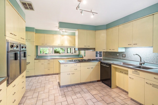 kitchen featuring cream cabinets, black dishwasher, and sink