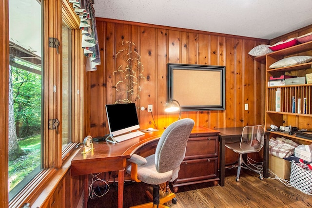 office featuring wood walls, dark wood-type flooring, a textured ceiling, and ornamental molding