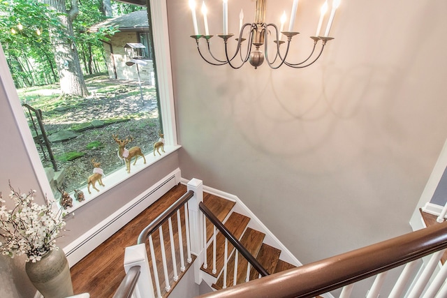 staircase featuring baseboard heating and hardwood / wood-style floors