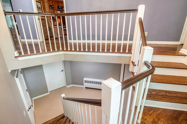 staircase with radiator and wood-type flooring