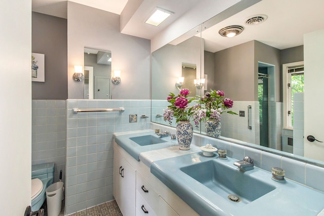 bathroom featuring vanity, tile patterned floors, and tile walls