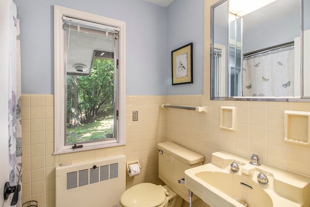 bathroom featuring a shower with shower curtain, toilet, tile walls, and radiator