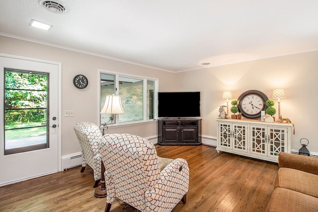 living room featuring wood-type flooring, crown molding, and a baseboard radiator