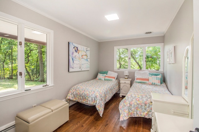 bedroom with dark hardwood / wood-style floors, crown molding, and a baseboard heating unit