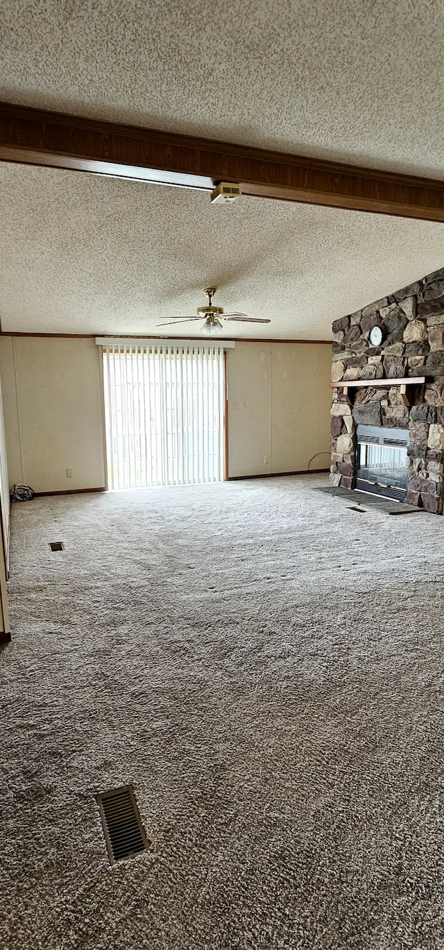 unfurnished living room featuring carpet flooring, a textured ceiling, ceiling fan, and a fireplace