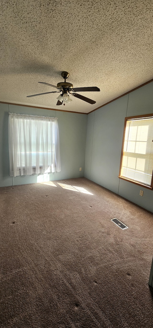 carpeted spare room with ceiling fan and a textured ceiling